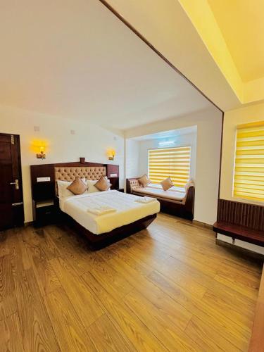 a large bedroom with a bed and a window at Kanavu Valley View in Ooty