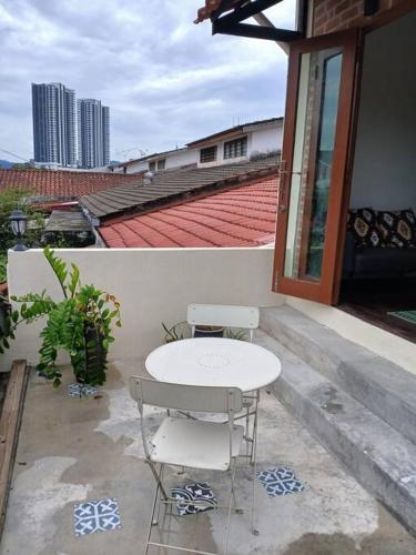 a white table and two chairs on a balcony at Preece's Homestay in Kuala Lumpur