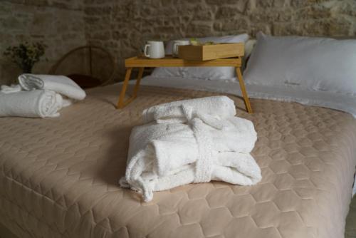 a bed with towels on it with a table at Wanderlust in Sannicandro di Bari