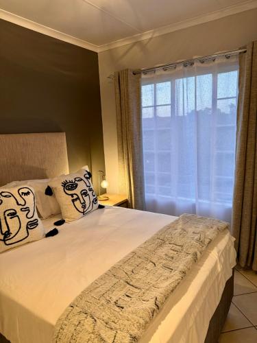 a bedroom with a large bed with a window at Centurion La Creme Apartments in Centurion