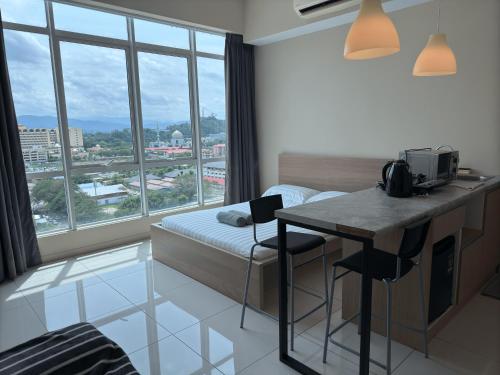 a hotel room with a bed and a desk and a window at Sutera Avenue Kota Kinabalu City Centre LW Suites in Kota Kinabalu