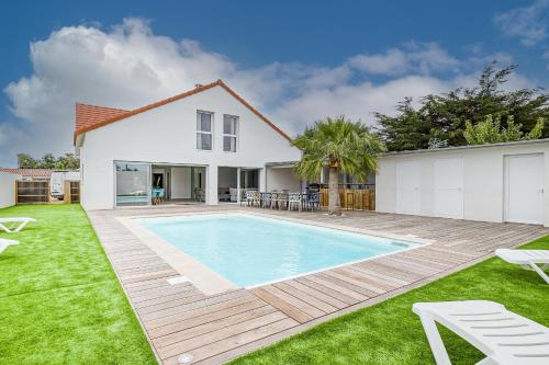 une maison avec une piscine dans une cour dans l'établissement Magnifique villa pour grande famille à La Barre-de-Monts, à La Barre-de-Monts