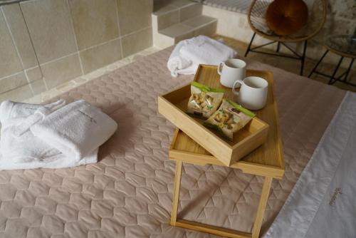 a table with a tray of food and two mugs on it at Wanderlust in Sannicandro di Bari
