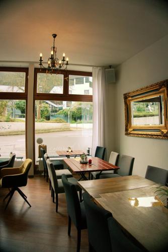 a dining room with tables and chairs and a large window at Schillers Hotel & Café - GARNI - in Lüdenscheid