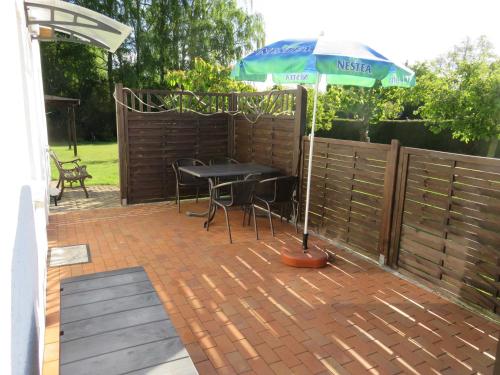 a patio with a table and an umbrella at Bungalow Alms in Ribnitz-Damgarten