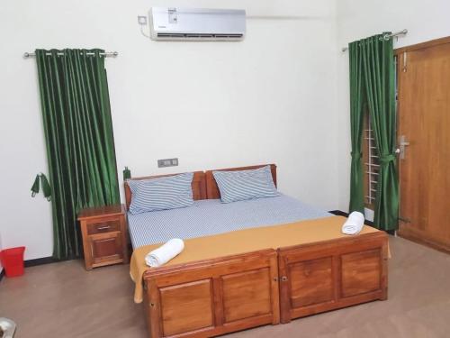 ein Schlafzimmer mit einem großen Bett mit grünen Vorhängen in der Unterkunft Krishnasila Homestay in Varkala