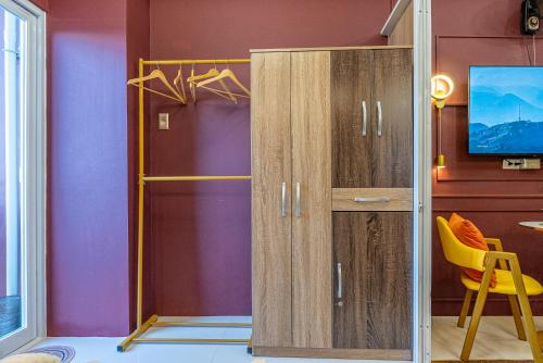 a room with a wardrobe and a yellow chair at Primeworld District Condo - Near Mactan Airport in Lapu Lapu City