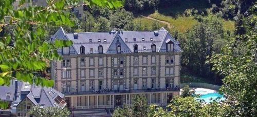 a large building with a pool in front of it at Le 41 - Cosy et Confort in Barèges