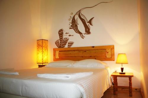 a bedroom with a bed with a fish on the wall at Kaafu Inn Guraidhoo in Guraidhoo