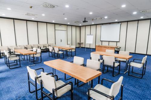 a classroom with tables and chairs and a whiteboard at Hotel Holiday in Sarajevo