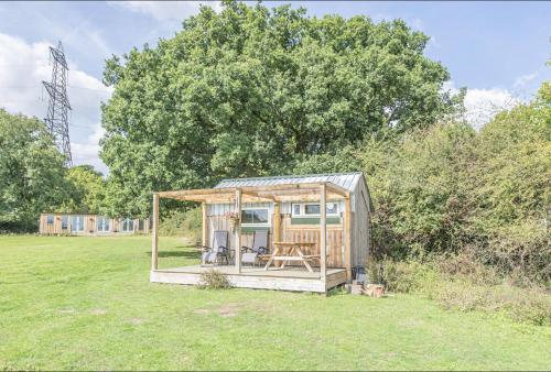 a small cabin in the middle of a field at Dartmoor Reach Alpaca Farm Heated Cabins 5 mins drive to Dartmoor in Bovey Tracey