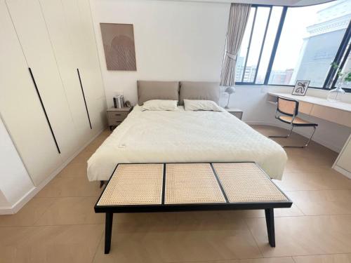 a bedroom with a large bed and a desk at Eastern Hub - Three Bedroom Apt in Xintiandi, 50m from Metro, Many Shops and Malls Surrounded in Shanghai