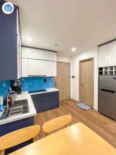 a kitchen with blue and white cabinets and a table at It Dust Homestay 1 - The Ocean Apartment in Hanoi