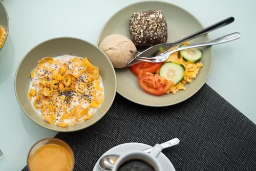 a table with two plates of food and a cup of coffee at Hotel Amadeos - Matosinhos - Porto in Matosinhos