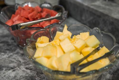 a glass bowl of fruit and a bowl of strawberries at Fenghuang Jiang'an Xinghe Hotel in Fenghuang
