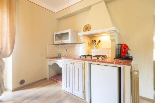 a kitchen with a stove and a microwave at Le Casaline by VacaVilla in Tepolini