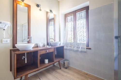 a bathroom with two sinks and a mirror at Le Casaline by VacaVilla in Tepolini