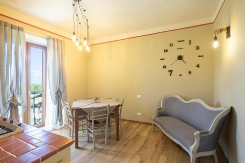 a dining room with a table and a clock on the wall at Le Casaline by VacaVilla in Tepolini