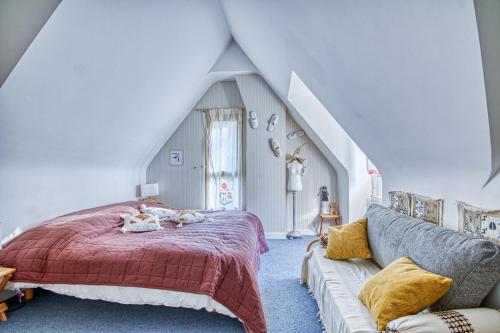 une chambre avec un lit et un canapé dans l'établissement La Rocherie - Charmante maison avec piscine privée, à Carnac
