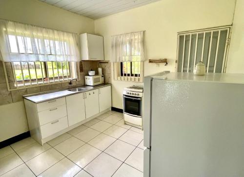 a kitchen with white cabinets and a refrigerator at 3 Bed House - Sleeps 6 - Garden - Parking - Wifi in Paramaribo