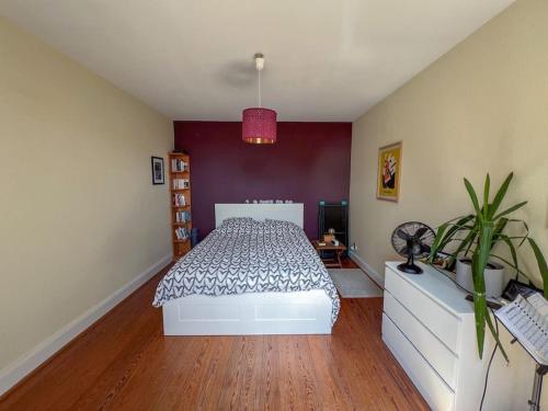 - une chambre avec un lit et un mur violet dans l'établissement Laiterie, appartement confort, à Strasbourg