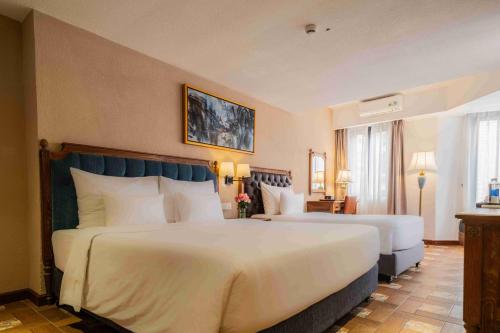 a large hotel room with two beds and a window at Venus Hotel Tam Đảo in Tam Ðảo