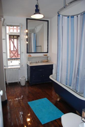 une salle de bain avec une baignoire, un lavabo et un miroir dans l'établissement Maison 5 chambres, jardinet, accès plage, à Trouville-sur-Mer