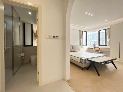 a bedroom with a bed and a table in a room at Eastern Hub - Three Bedroom Apt in Xintiandi, 50m from Metro, Many Shops and Malls Surrounded in Shanghai
