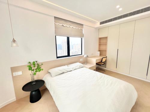 a white bedroom with a bed and a table at Eastern Hub - Three Bedroom Apt in Xintiandi, 50m from Metro, Many Shops and Malls Surrounded in Shanghai