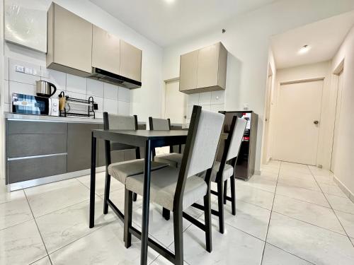 a kitchen with a black dining table and chairs at The Sun Residence Bayan Lepas in Bayan Lepas