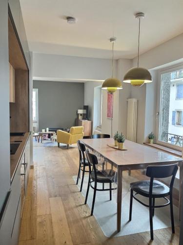 une cuisine et une salle à manger avec une table et des chaises dans l'établissement Magnifique Appartement au Centre de Chamonix, à Chamonix-Mont-Blanc