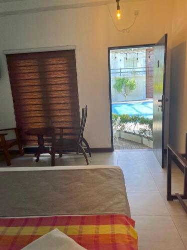 a room with a bed and a chair and a window at Royal Crown Residency Hotel in Talawatugoda
