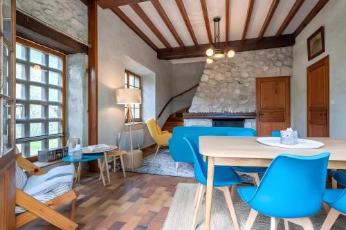 une salle à manger avec des chaises bleues et une table dans l'établissement Maison Jumelée avec terrasse - A 200m du lac d'Annecy, à Sévrier