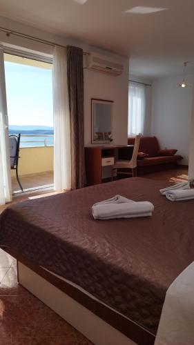 a bedroom with a large bed with a view of the ocean at Apartmani Adriatica 2 in Dramalj