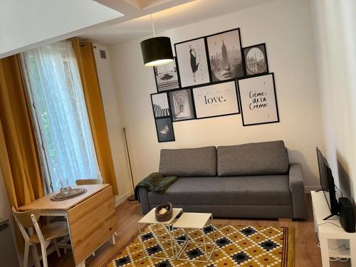 - un salon avec un canapé et des photos sur le mur dans l'établissement Appartement de 27 m2 agréable et lumineux idéalement situé au coeur de la ville de Pierrefitte-sur-Seine, à Pierrefitte-sur-Seine