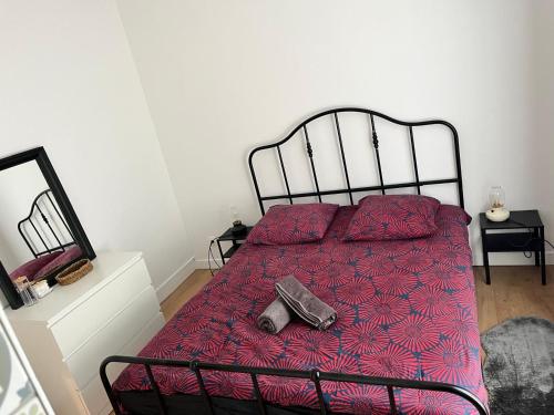 une chambre avec un lit avec une couette rouge dans l'établissement Appartement de 27 m2 agréable et lumineux idéalement situé au coeur de la ville de Pierrefitte-sur-Seine, à Pierrefitte-sur-Seine