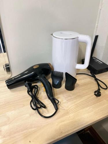 a black phone sitting on a desk next to a cup at The Hidden Sao Chingcha in Bangkok