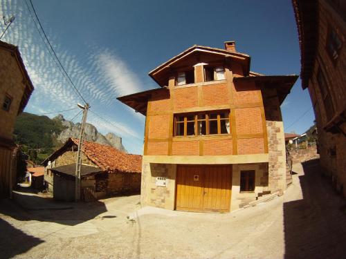 a tall building with a wooden door on a street at Viviendas Rurales El Cantón in Cucayo