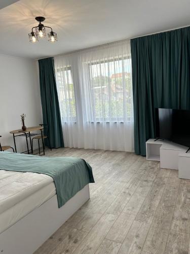 a bedroom with a bed and a flat screen tv at Axon Apartments in Oradea