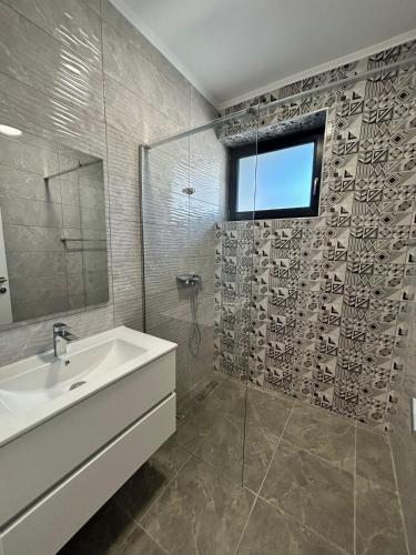 a bathroom with a sink and a glass shower at Axon Apartments in Oradea