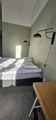 a bedroom with a bed and two lights on the wall at Stora Ekeberg vandrarhem in Axvall