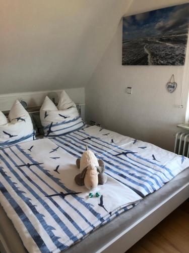 a stuffed animal sitting on top of a bed at Wattlöwe ruhige Ferienwohnung mit Terrasse nahe Eider & Deich in Tönning