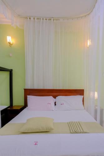 Uma cama ou camas num quarto em Crystal Apartments Entebbe Uganda Next to UN Base