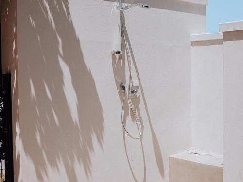 a shower in a bathroom with a hose on a wall at KnusRus in Jongensfontein