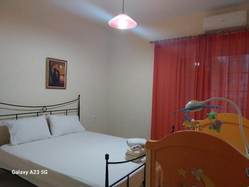 a bedroom with a bed and a red curtain at Menidi apartment Β in Menídion
