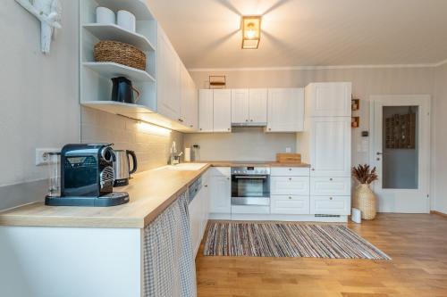 a kitchen with white cabinets and a counter top at Highland Moments Apartment - by myNests in Gröbming