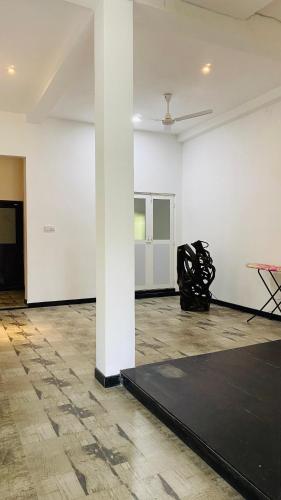 a room with a black rug and a white wall at COCO Rooms in Galle