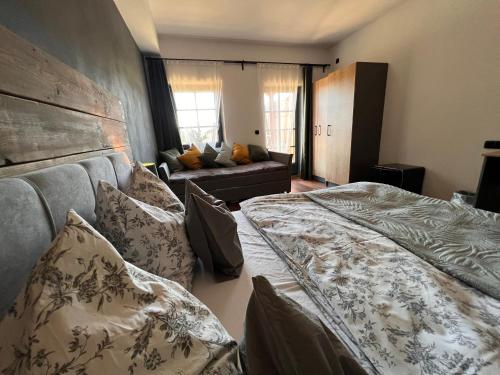 a bedroom with two beds and a couch at Penzion Farma Žleby in České Žleby