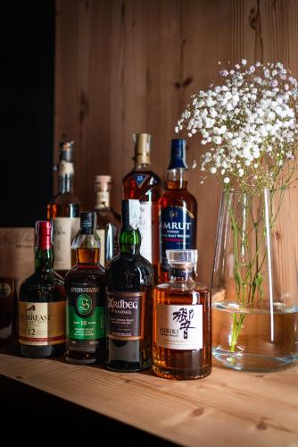 a group of bottles of whiskey sitting on a shelf at Hotel Frangart an der Weinstraße in Appiano sulla Strada del Vino