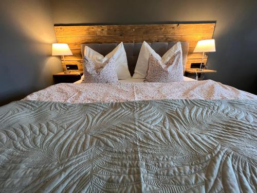 a large bed with two pillows on top of it at Penzion Farma Žleby in České Žleby